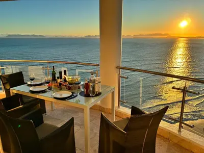 a table on a balcony with a view of the ocean at Main Hibernian Penthouse in Strand