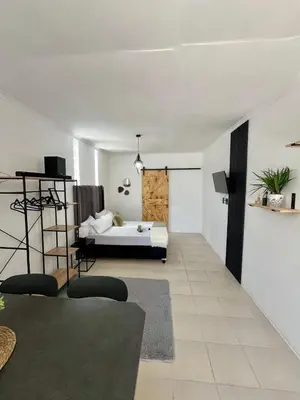 a bedroom with a bed and a room with a couch at Angel's Cottage in Paarl