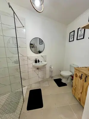 a bathroom with a toilet and a sink and a mirror at Angel's Cottage in Paarl
