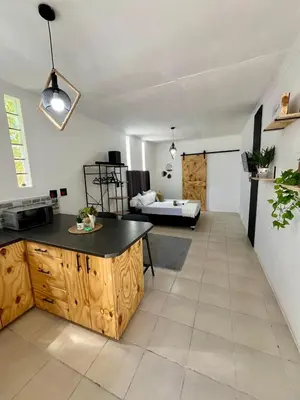 a kitchen and living room with a table and a couch at Angel's Cottage in Paarl