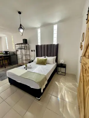 a bedroom with a large bed in a room at Angel's Cottage in Paarl
