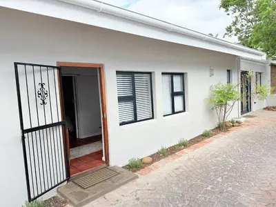 a white house with a gate in front of it at Die Stal in Wellington