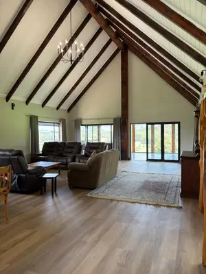 a large living room with a vaulted ceiling with exposed beams at Shiloh Lodges Kamberg in Sir Lowry Pass