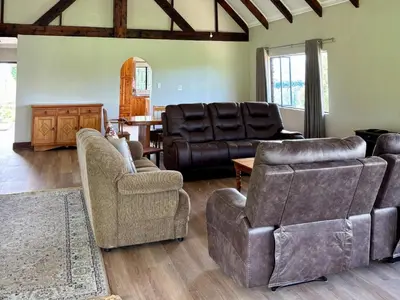 a living room with couches and chairs and a table at Shiloh Lodges Kamberg in Sir Lowry Pass