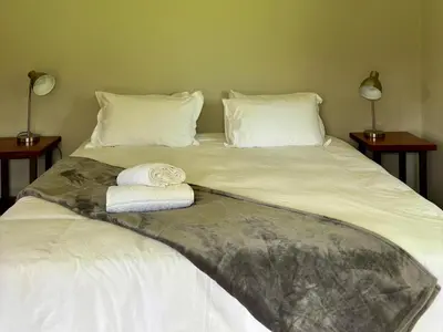 a bed with two towels on top of it at Shiloh Lodges Kamberg in Sir Lowry Pass