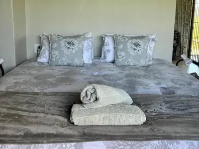 a bed with a dog laying on top of it at Shiloh Lodges Kamberg in Sir Lowry Pass