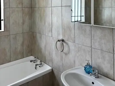 a bathroom with a sink and a bath tub at Shiloh Lodges Kamberg in Sir Lowry Pass