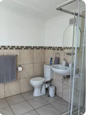 a bathroom with a toilet and a sink at Fijnbos in Strand