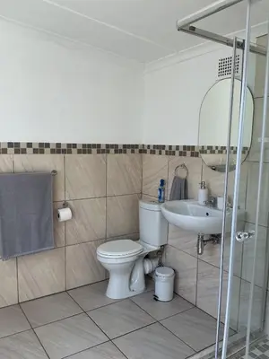 a bathroom with a toilet and a sink at Fijnbos in Strand