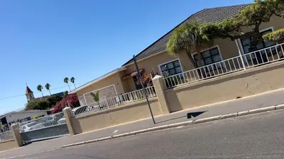 a building with a fence and an arrow on the street at Home of peace self catering accommodation