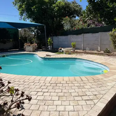 a swimming pool in a yard with a brick patio at Home of peace self catering accommodation