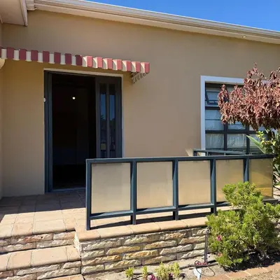 a house with a fence in front of a door at Home of peace self catering accommodation
