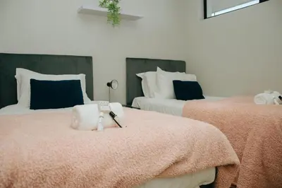 a bedroom with two beds with a robe on them at Sea Facing 2 Bedroom Apartment In Burmeister On Park, Milnerton in Cape Town