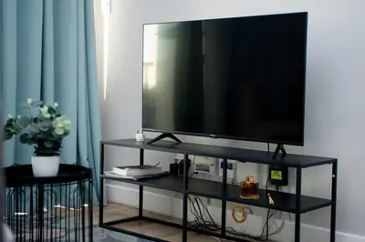 a flat screen tv sitting on a black entertainment center at Sea Facing 2 Bedroom Apartment In Burmeister On Park, Milnerton in Cape Town