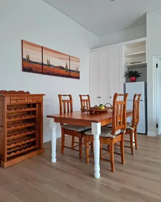 a dining room with a wooden table and chairs at Bird's Landing in Hermanus