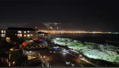a view of a city at night with lights at Cozy Apartment with Table Mountain and beach views in Cape Town