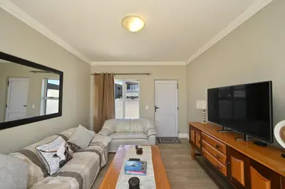 a living room with a couch and a flat screen tv at The lodge in Cape Town