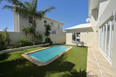 a backyard with a swimming pool and a house at The lodge in Cape Town