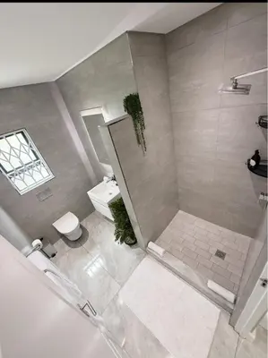 a large bathroom with a shower and a toilet at Canal Walk Luxury 2 Bedroom Apartments in Cape Town