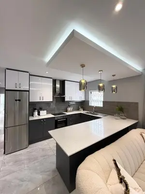 a kitchen with a couch and a table in it at Canal Walk Luxury 2 Bedroom Apartments in Cape Town
