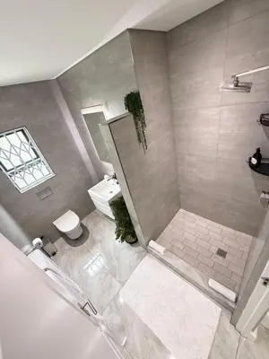 a bathroom with a shower and a toilet and a sink at Canal Walk Luxury 2 Bedroom Apartments in Cape Town