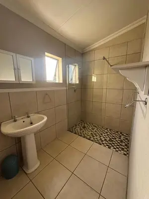 a white bathroom with a sink and a shower at The Old Silver Oaks Farm Cottage