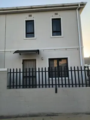 a white house with a black fence at Coastal Guest House with Free Parking and Braai Area in Cape Town