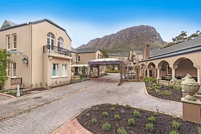 a cobblestone driveway in front of a house at L'Ermitage Chateau and Villas at Villa 80 in Franschhoek
