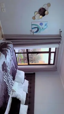 a room with a window and a couch with towels at De Groove Luxury Homes in Cape Town