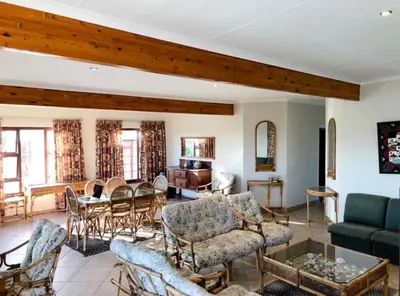 a living room with a couch and a table at Pura Vida Hermanus in Hermanus