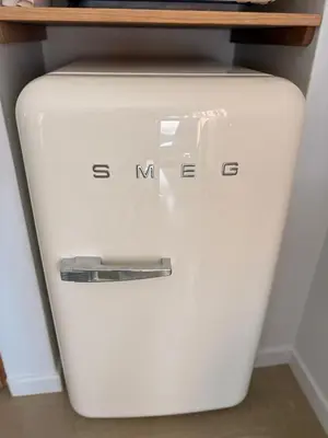 a white toilet in a room with a shelf on top at The Oak Cottage in Wellington