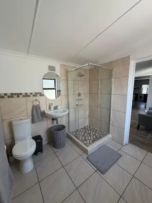 a bathroom with a shower and a toilet and a sink at Fijnbos Strand in Strand