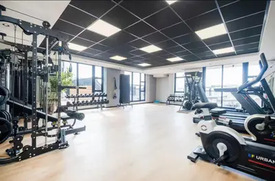a gym with treadmills ellipticals and tread machines at Stylish Executive Studio with Balcony in Riverlands, Observatory in Cape Town