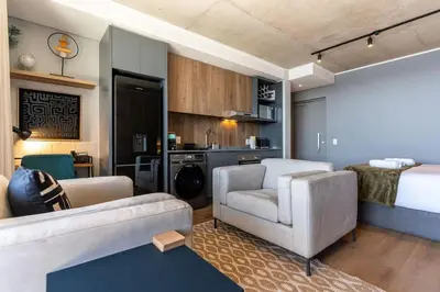 a living room with a couch and a bed at Stylish Executive Studio with Balcony in Riverlands, Observatory in Cape Town