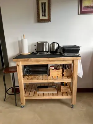 a wooden cart with a microwave on top of it at BEACH FRONT Side Studio, 50 steps to main beach in Pringle Bay