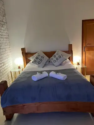 a bedroom with a bed with two slippers on it at BEACH FRONT Side Studio, 50 steps to main beach in Pringle Bay