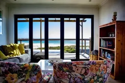 a living room with a couch and a view of the ocean at The Red Door in Pringle Bay