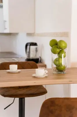 a table with a vase of green apples on it at 7th Heaven Lodge in Gordonʼs Bay