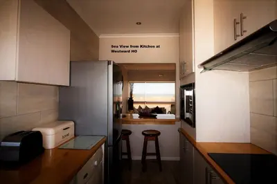 a kitchen with two bar stools and a counter top at Westward HO Apartment 13 in Cape Town