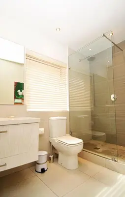 a bathroom with a toilet and a glass shower at bamboo @ Le Paradis in Hermanus