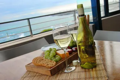 a table with a bottle of wine and a tray of grapes and bread at bamboo @ Le Paradis in Hermanus