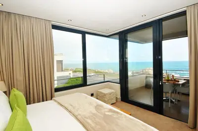 a bedroom with a bed and a view of the ocean at bamboo @ Le Paradis in Hermanus