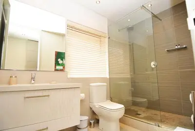 a bathroom with a toilet and a glass shower at bamboo @ Le Paradis in Hermanus