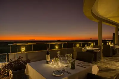 a table with a bottle of wine and glasses on a balcony at Atlantic Palms in Cape Town