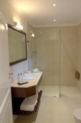 a bathroom with a sink and a glass shower at Clos Malverne Wine Estate in Stellenbosch