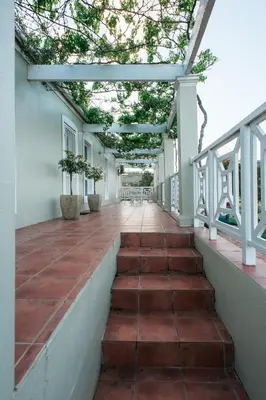 an outdoor walkway with plants in pots on a building at Clos Malverne Wine Estate in Stellenbosch