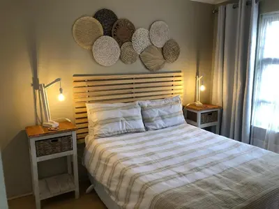 a bedroom with a bed and two tables with lamps at 10 On Ou Kraal in Edgemead