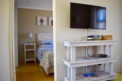 a bedroom with a television on a shelf with a bed at 10 On Ou Kraal in Edgemead