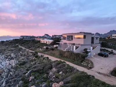 a house on top of a hill with the ocean at Villa Marine Guest House in Pringle Bay