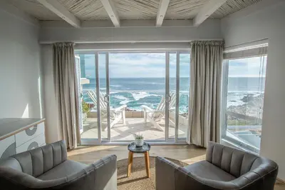 a living room with a view of the ocean at Villa Marine Guest House in Pringle Bay